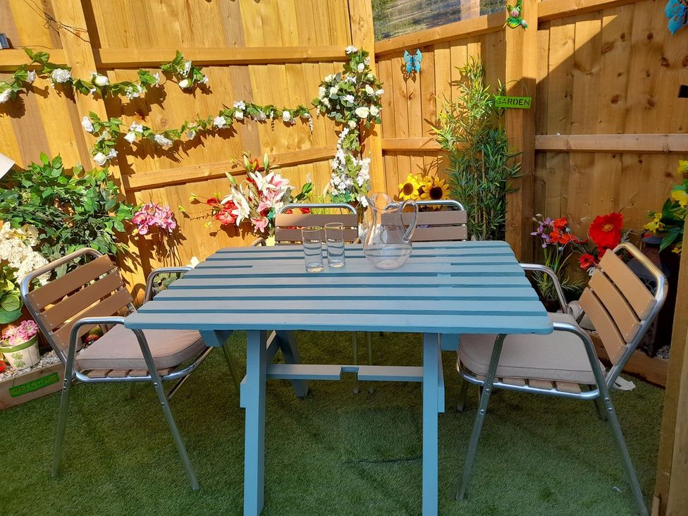 A garden setting with a table and chairs at Greenham Rise in Norton-Sub-Hamdon