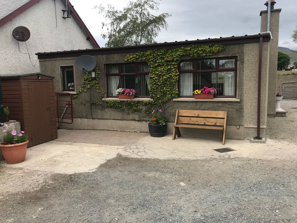 An outdoor area with a bench and flower pots at 87 Ballyveaghmore Road in Newry