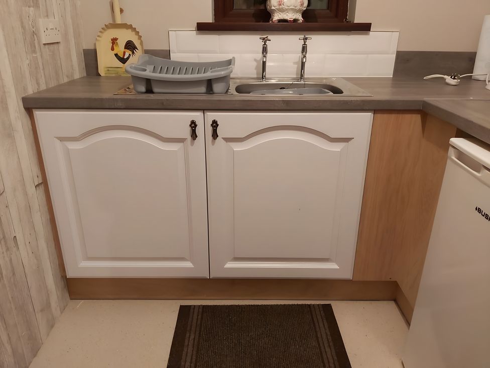 A sink and cupboards in a kitchen at 87 Ballyveaghmore Road Newry