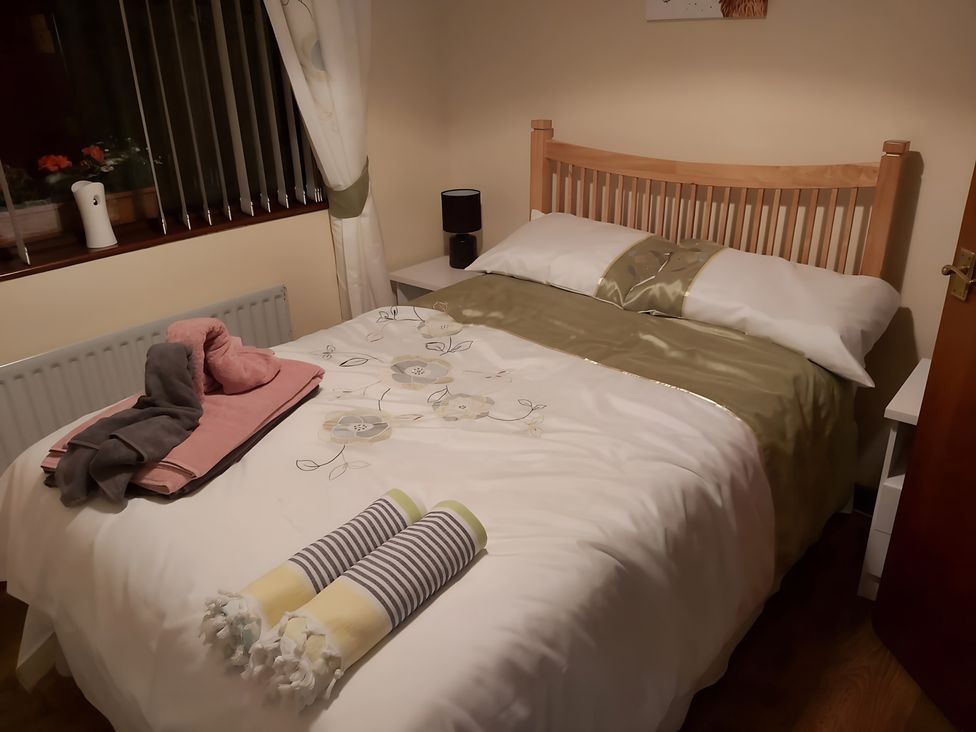 A bedroom with a bed and towels at 87 Ballyveaghmore Road in Newry