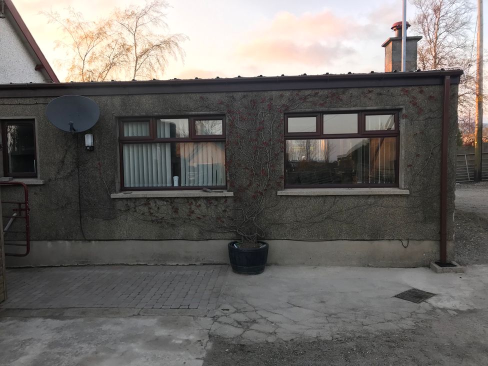 An outdoor view of a building with windows and a satellite dish at 87 Ballyveaghmore Road in Newry