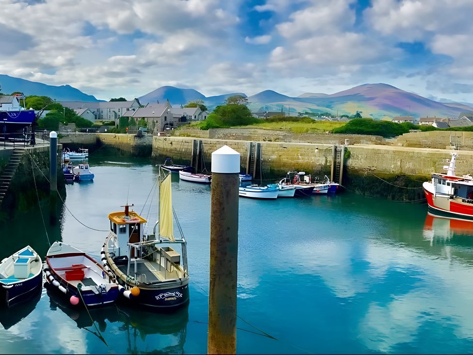 A marina with boats and mountains in the background at 87 Ballyveaghmore Road, Newry