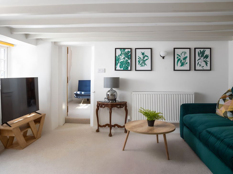 A living room with a television and sofa at The Cottage in Helston