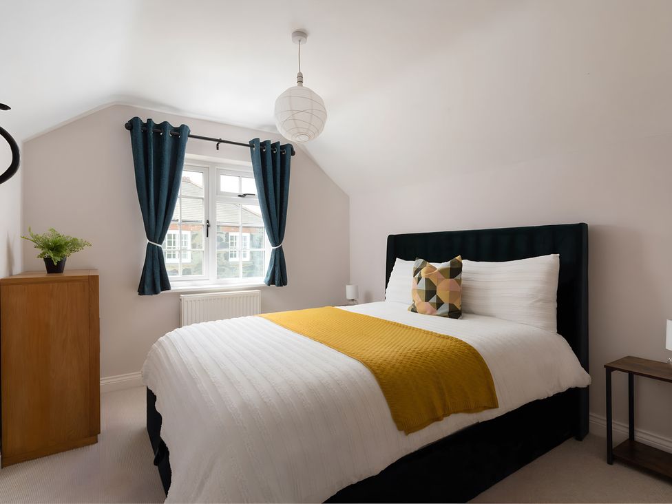 A bedroom with a bed and a window at The Cottage in Helston