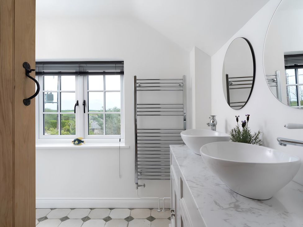 A bathroom with sinks and a window at The Cottage in Helston