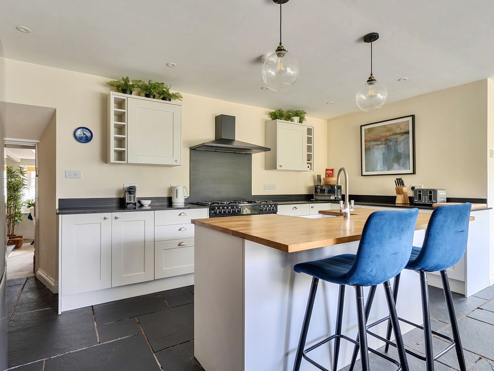 A kitchen with a stove and sink at The Cottage in Helston
