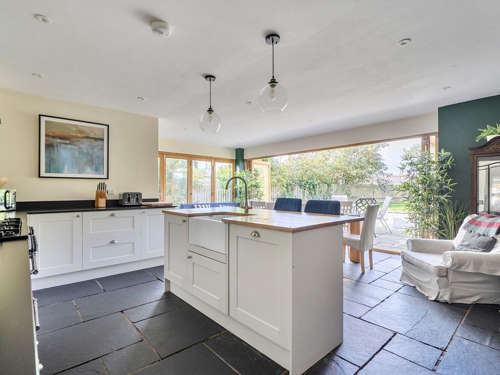 A kitchen with an island and dining area at The Cottage in Helston