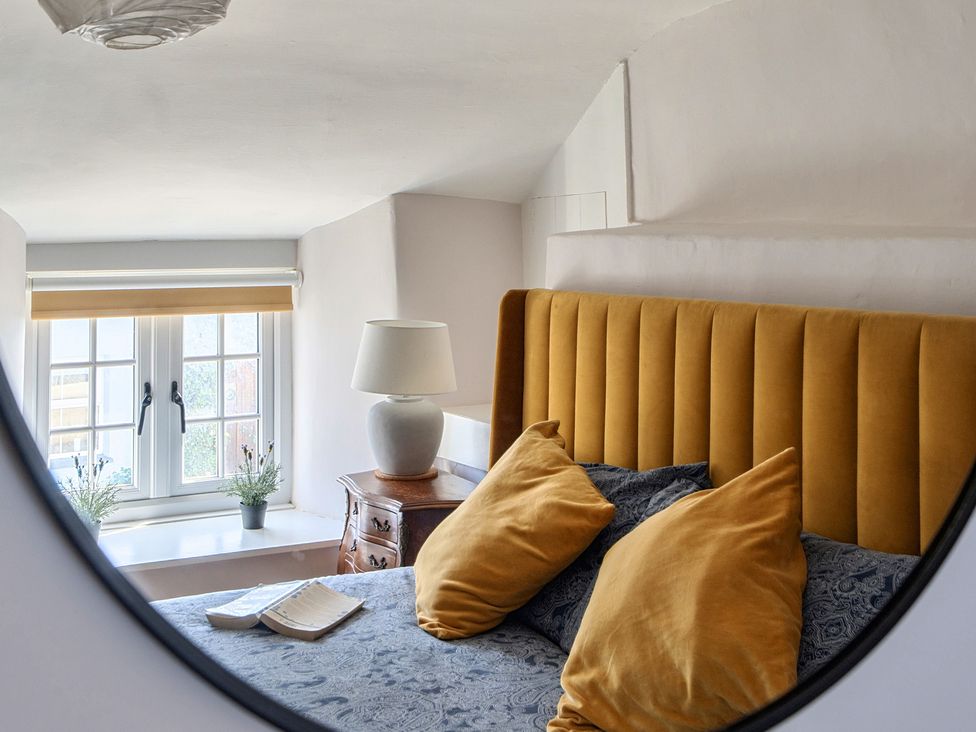 A bedroom with a bed and decorative pillows at The Cottage in Helston