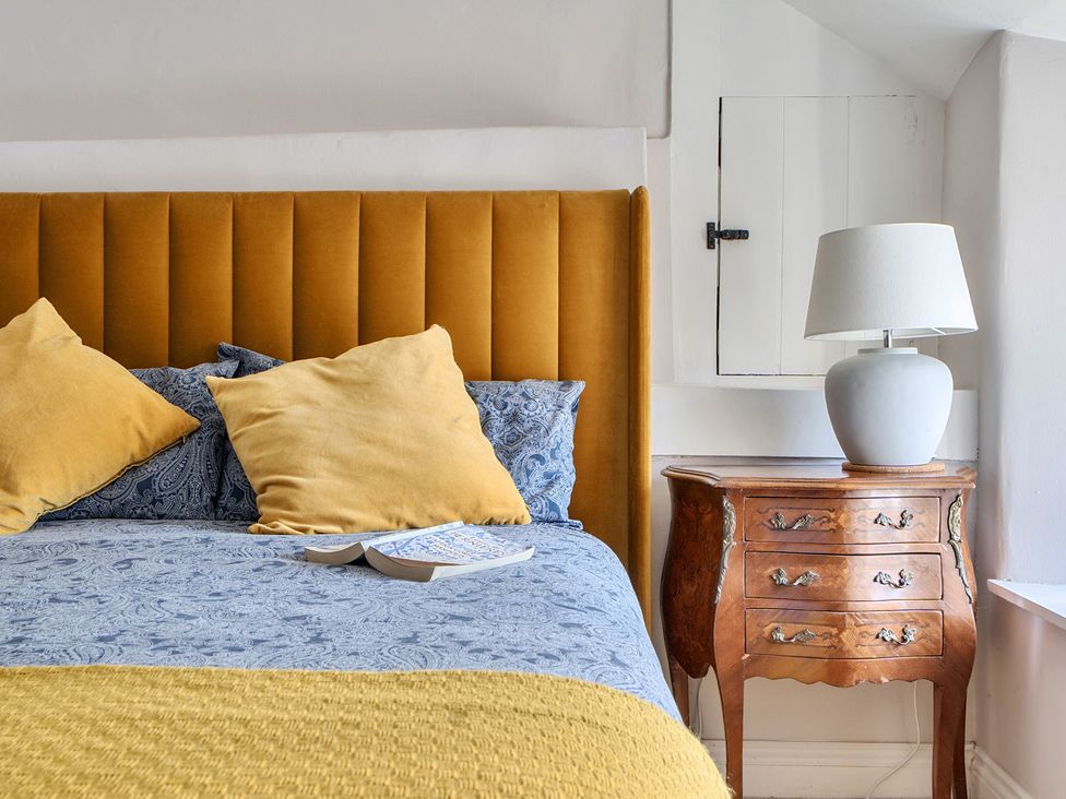 A bedroom with a bed and a nightstand at The Cottage in Helston