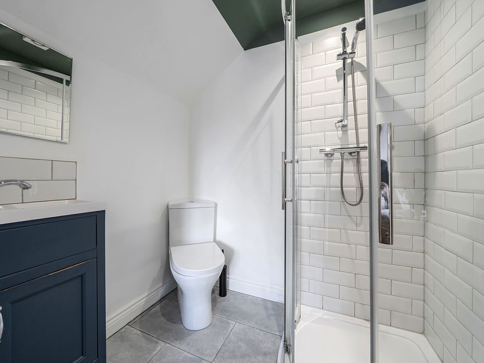 A bathroom with a sink, toilet, and shower at The Cottage in Helston