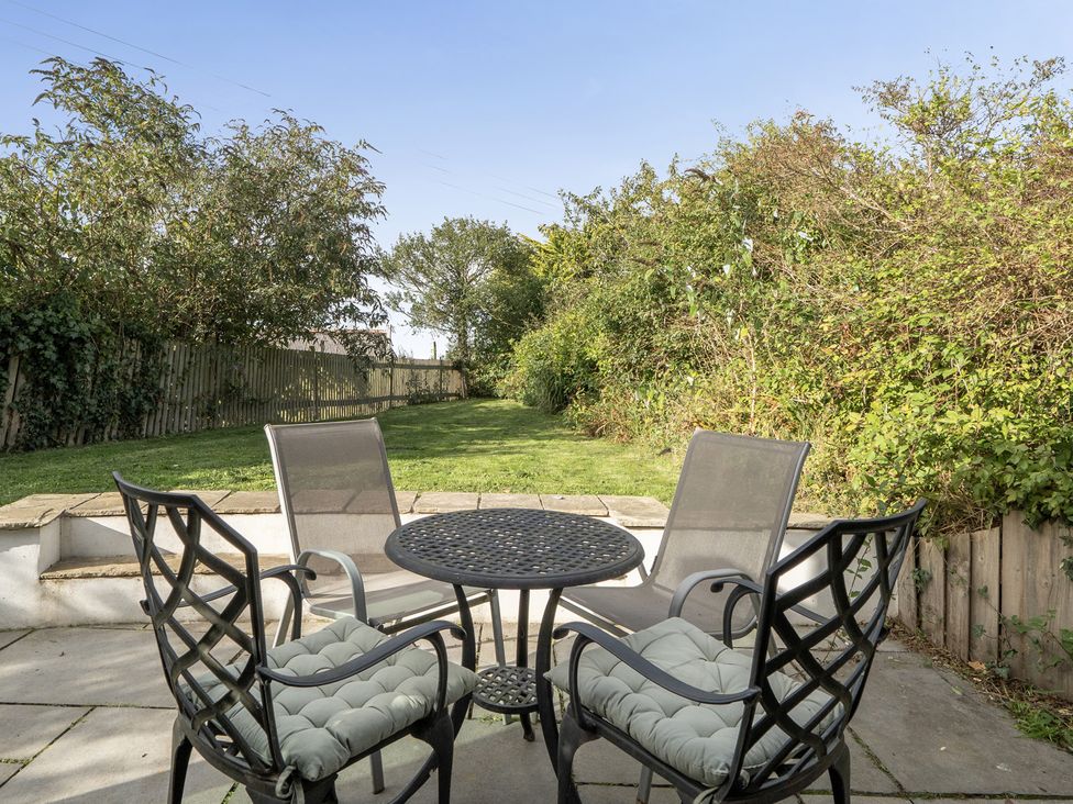 A garden with a table and chairs at The Cottage in Helston