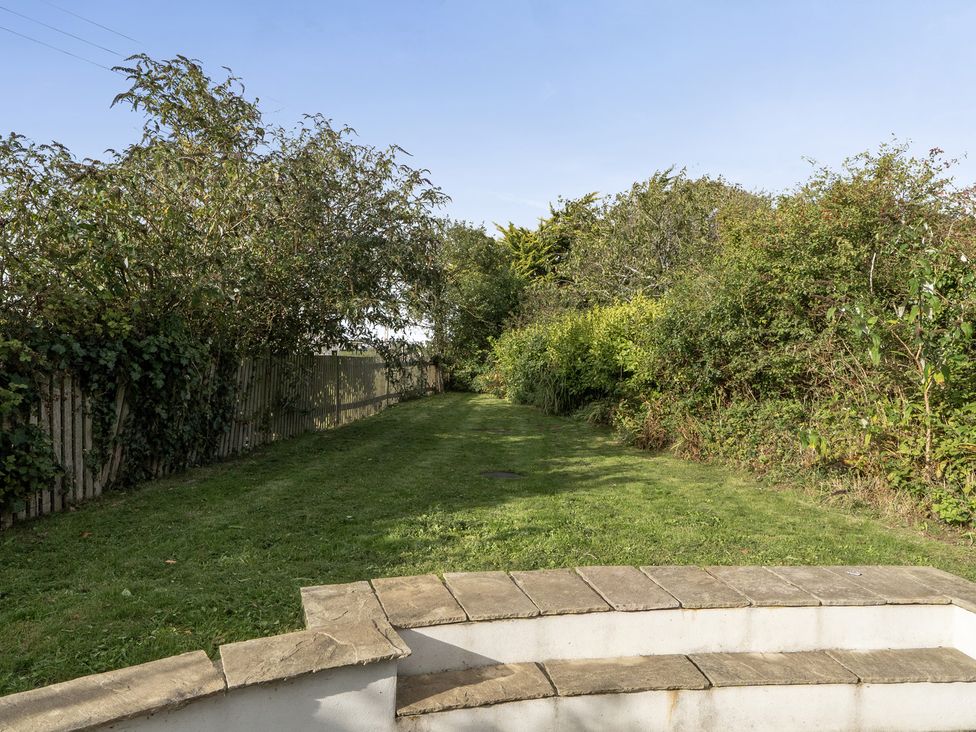 A garden with a pathway and bushes at The Cottage in Helston