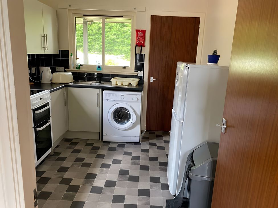 A kitchen with appliances and a washing machine at 9 Creag An Iolaire near Portree