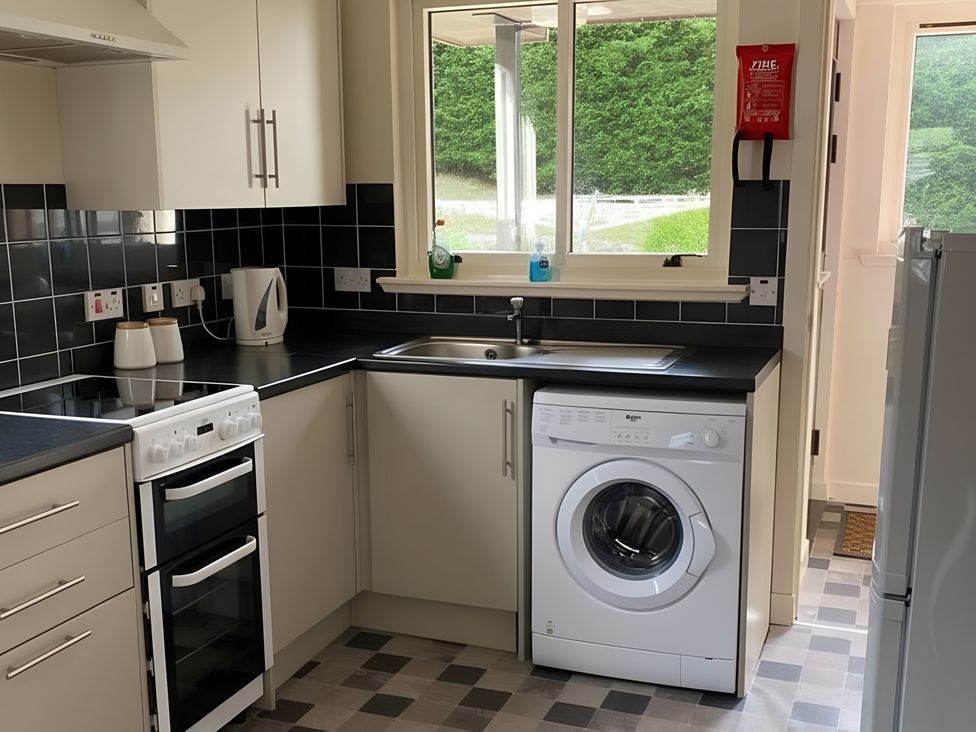 A kitchen with an oven and a washing machine at 9 Creag An Iolaire near Portree