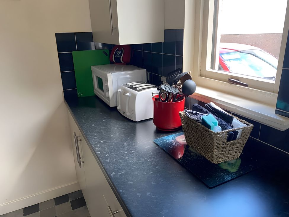 A kitchen with a microwave, toaster, and utensils at 9 Creag An Iolaire Near Portree