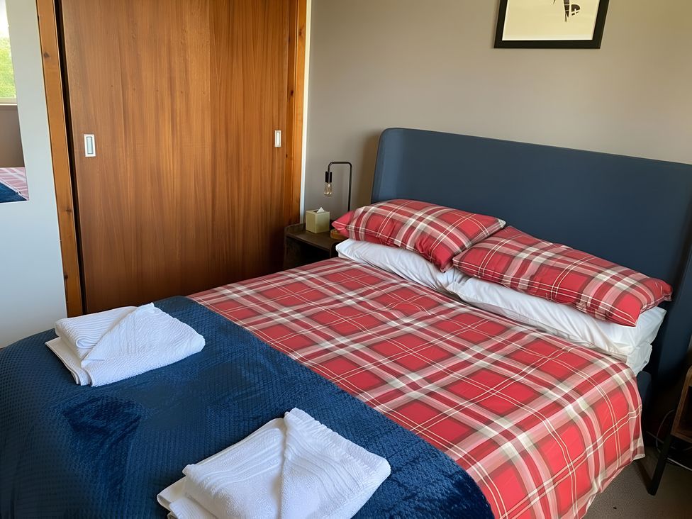 A bedroom with a bed and wardrobe at 9 Creag An Iolaire near Portree