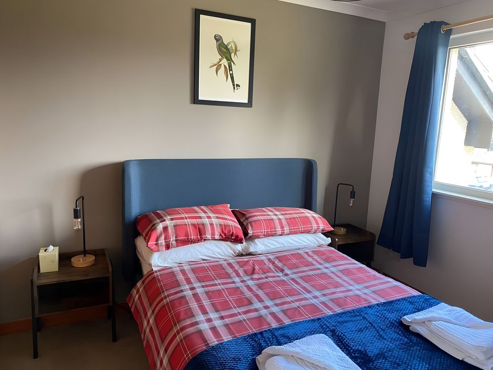 A bedroom with a bed and bedside tables at 9 Creag An Iolaire near Portree