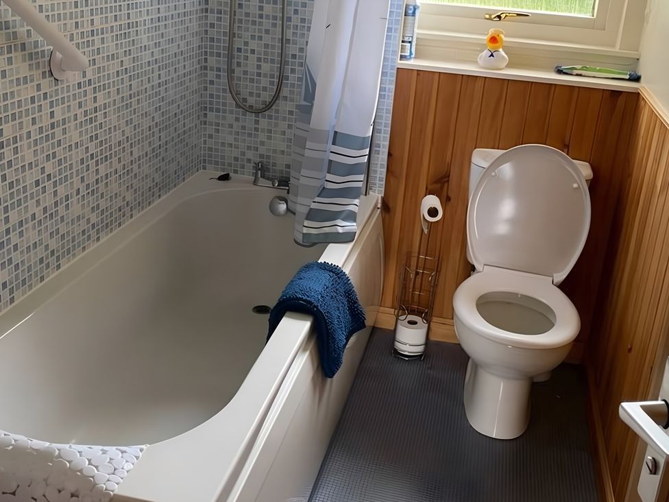 A bathroom with a bathtub and toilet at 9 Creag An Iolaire near Portree