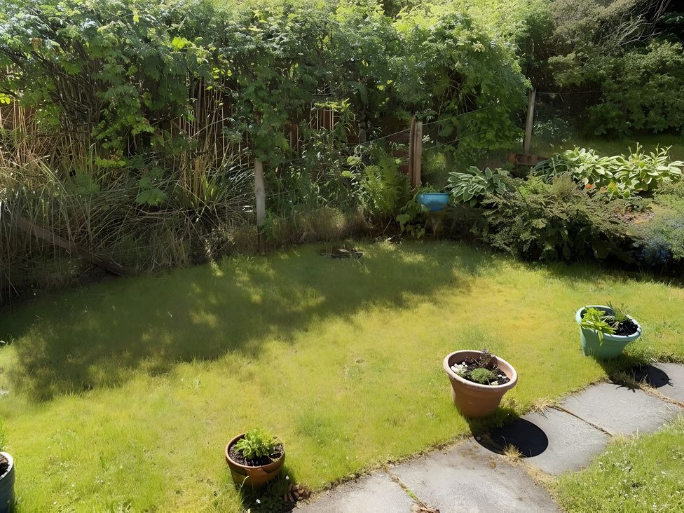 A garden with grass and plant pots at 9 Creag An Iolaire Near Portree
