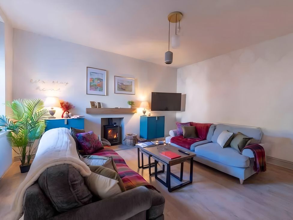 A living room with a sofa, armchair and fireplace at 29 Chapel Street in Appleby-In-Westmorland