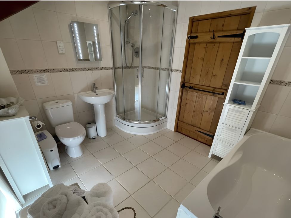 A bathroom with a shower, sink, toilet, and bathtub at Granary Barn in Winkleigh