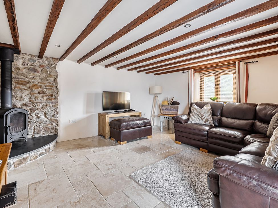 A living room with a sofa and television at Granary Barn in Winkleigh