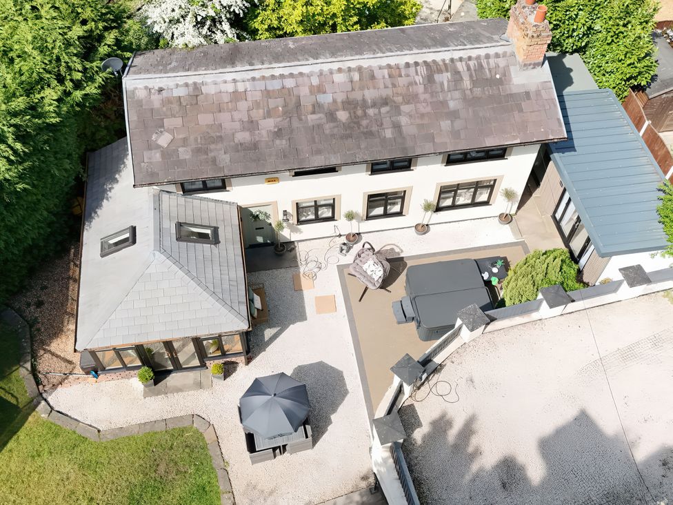 An outdoor view of a house with garden and furniture at Rainbow Cottage in Ormskirk