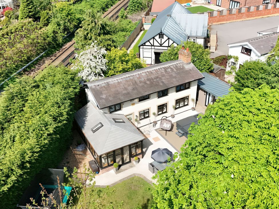 An outdoor view of a house with garden and patio at Rainbow Cottage in Ormskirk