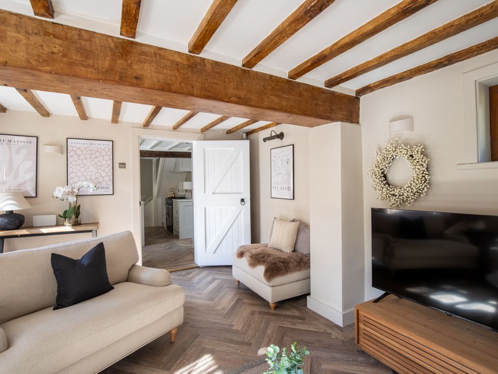 A living room with a couch and television at Rainbow Cottage in Aughton near Ormskirk