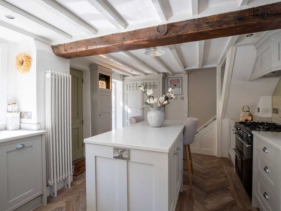A kitchen with an island and a radiator at Rainbow Cottage Aughton near Ormskirk