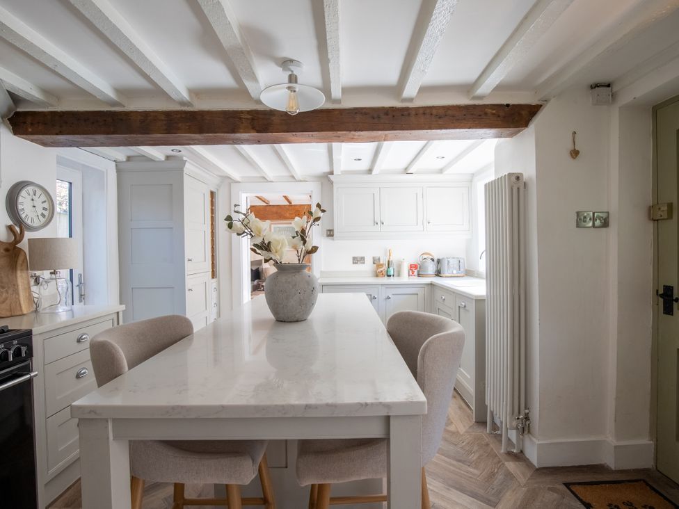 A kitchen with a table and chairs at Rainbow Cottage in Aughton near Ormskirk