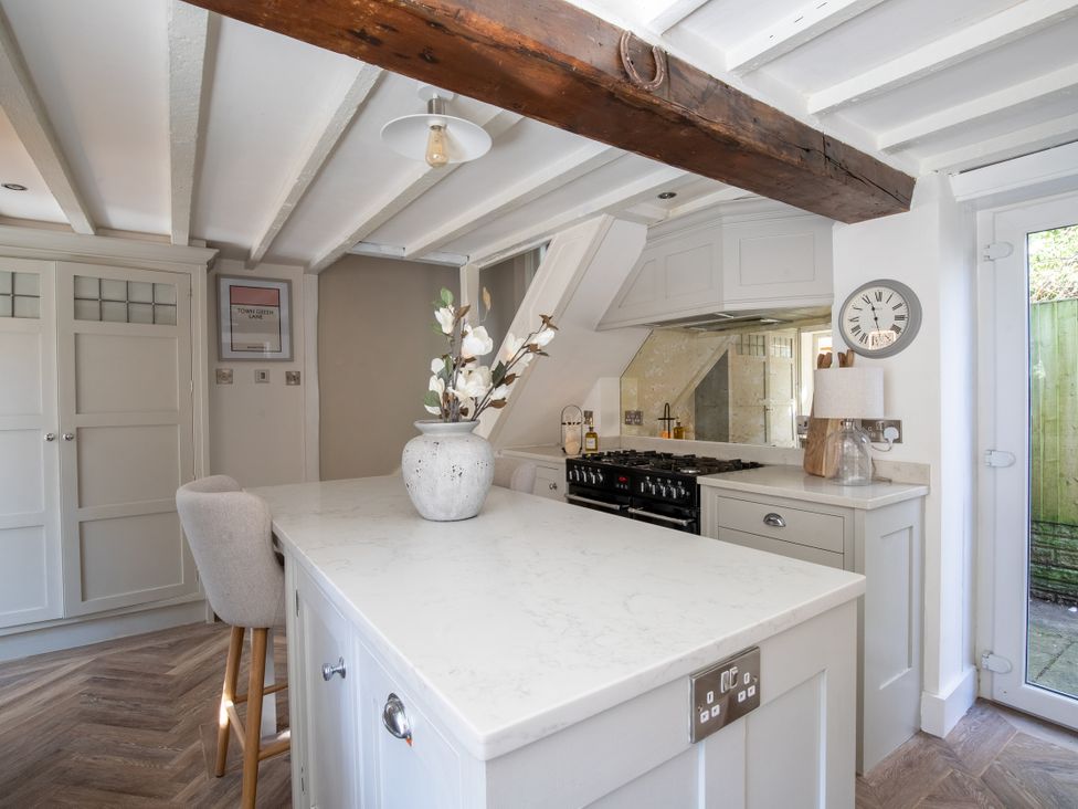 A kitchen with an island and a stove at Rainbow Cottage Aughton near Ormskirk