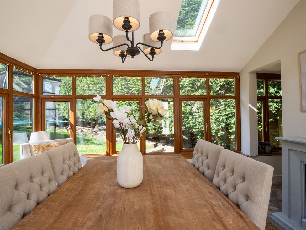 A dining room with a table and chairs at Rainbow Cottage in Aughton near Ormskirk