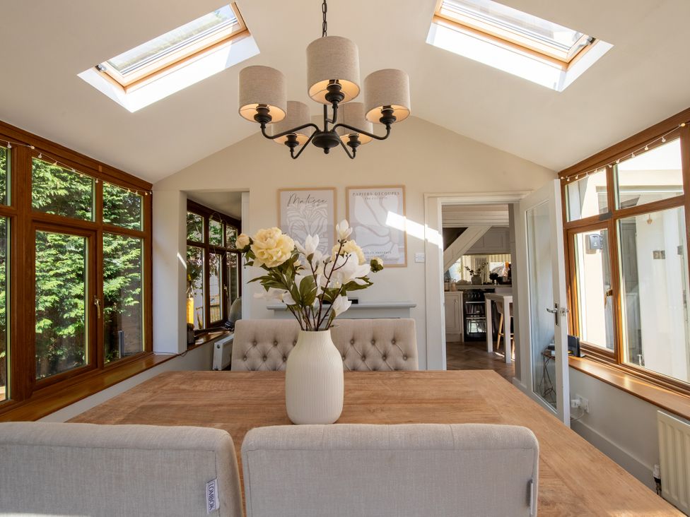 A dining room with a table and chairs at Rainbow Cottage in Aughton near Ormskirk