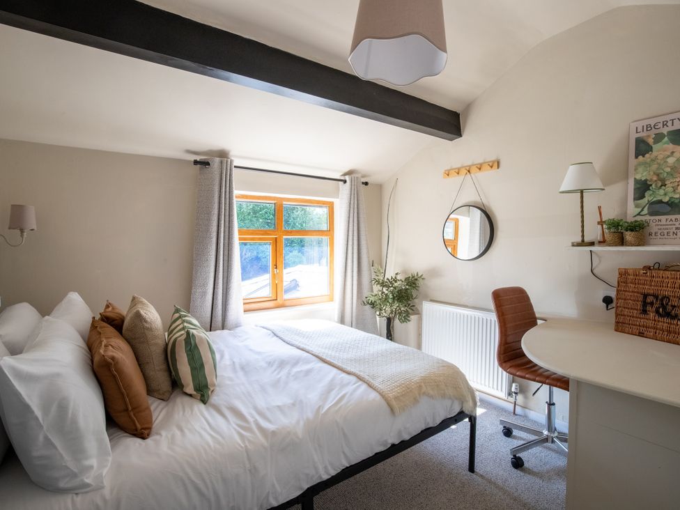 A bedroom with a bed and desk at Rainbow Cottage in Aughton near Ormskirk
