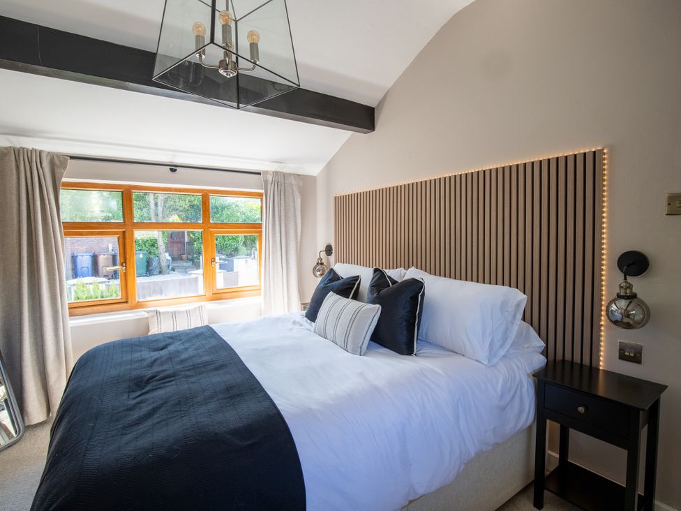 A bedroom with a bed and window at Rainbow Cottage Aughton near Ormskirk