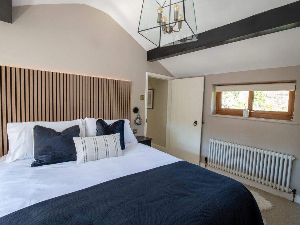 A bedroom with a bed and a window at Rainbow Cottage in Aughton near Ormskirk