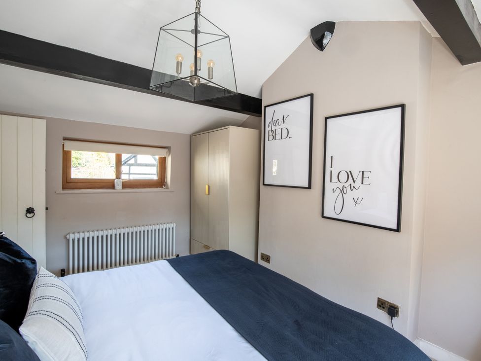 A bedroom with a bed and wall art at Rainbow Cottage in Aughton near Ormskirk