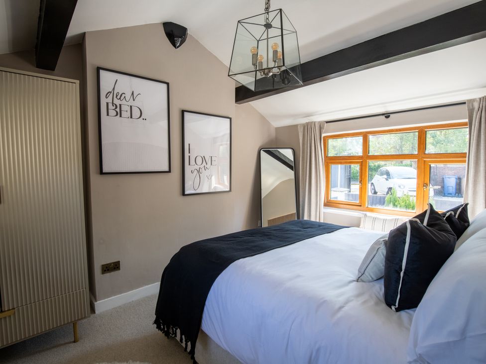 A bedroom with a bed and window at Rainbow Cottage in Aughton near Ormskirk