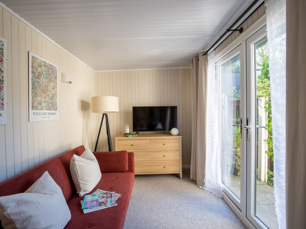 A living room with a television and a sofa at Rainbow Cottage Aughton near Ormskirk