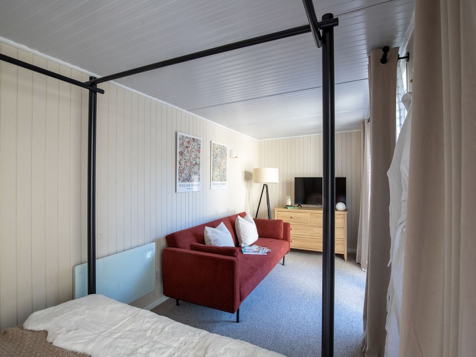A living room with a sofa and television at Rainbow Cottage in Aughton near Ormskirk