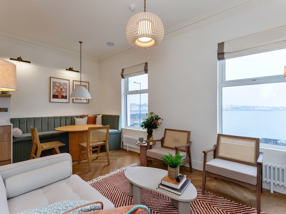 A living room with a dining area and a view at Seafront Apartment in Donaghadee