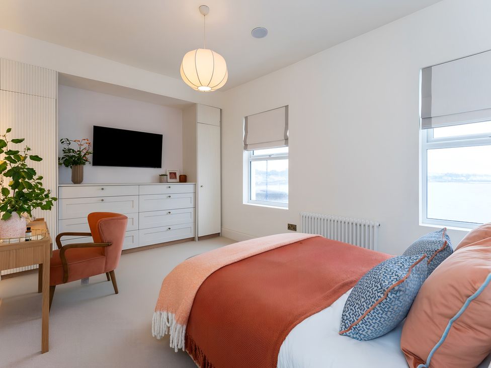 A bedroom with a bed and television at Seafront Apartment in Donaghadee