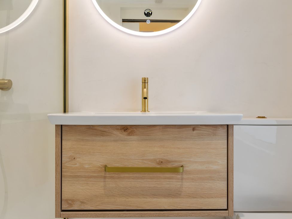 A sink and vanity with a faucet and mirror at Seafront Apartment in Donaghadee