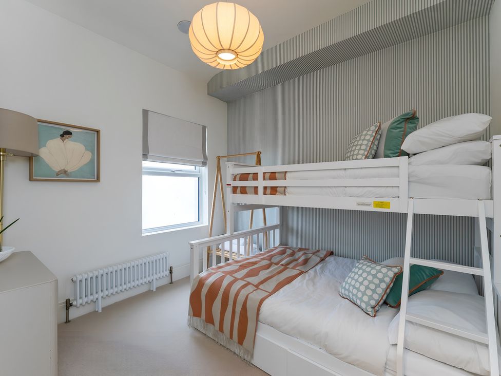 A bedroom with a bunk bed and a single bed at Seafront Apartment in Donaghadee