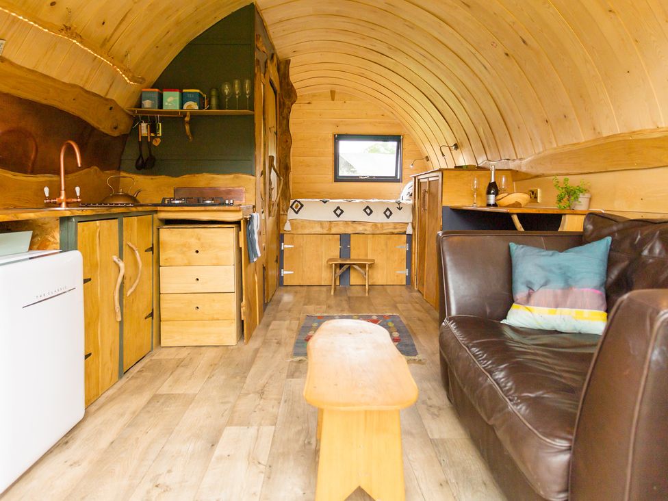 A living room with a kitchen area and a sofa at Glamping pod-Luxury Glamping Retreat in Battle