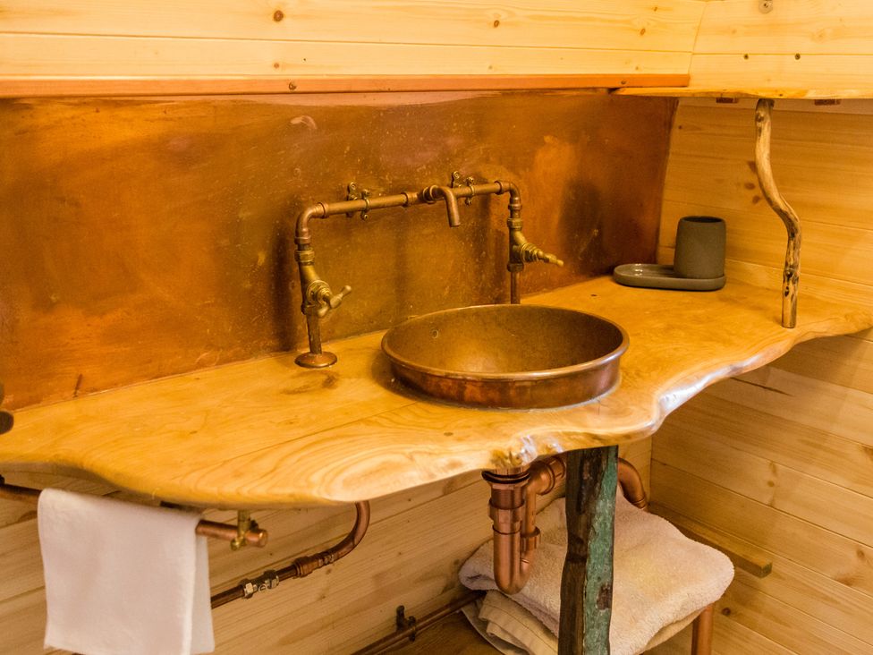 A bathroom with a wooden sink and faucet at Glamping pod-Luxury Glamping Retreat in Battle