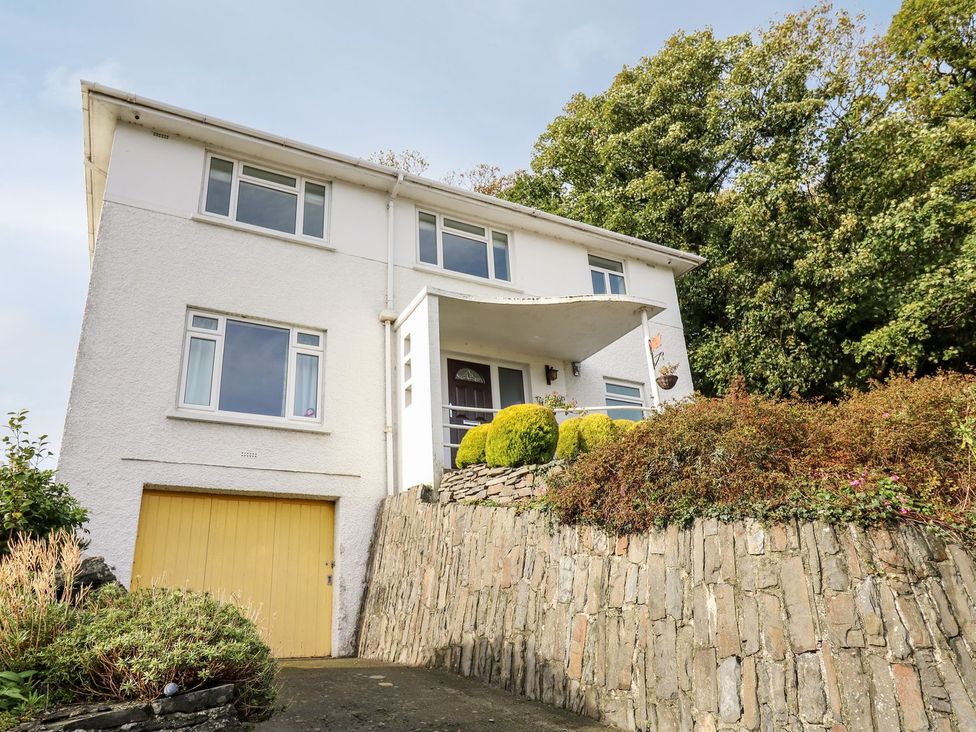 A house with a garage and stone wall at Tymelyn in Aberystwyth