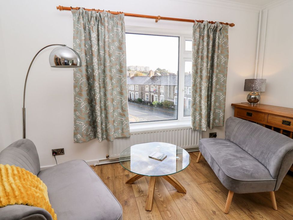 A living room with a lamp and a sofa at Tymelyn in Aberystwyth