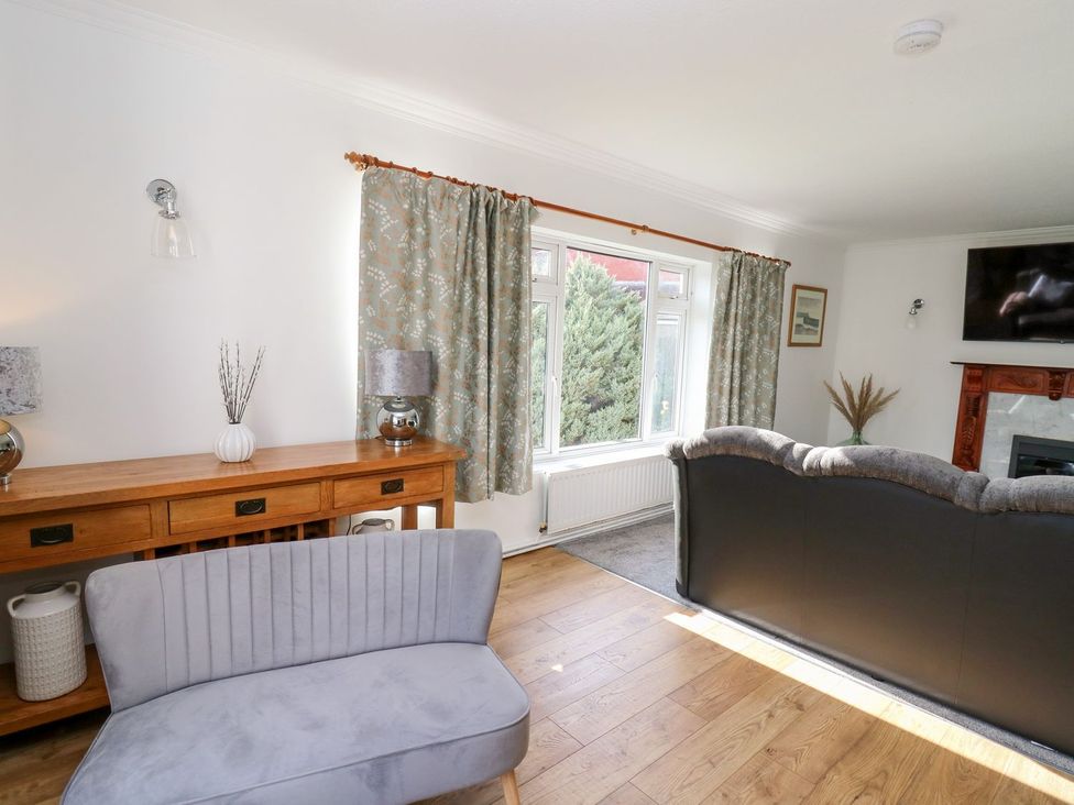 A living room with a sofa and a window at Tymelyn in Aberystwyth
